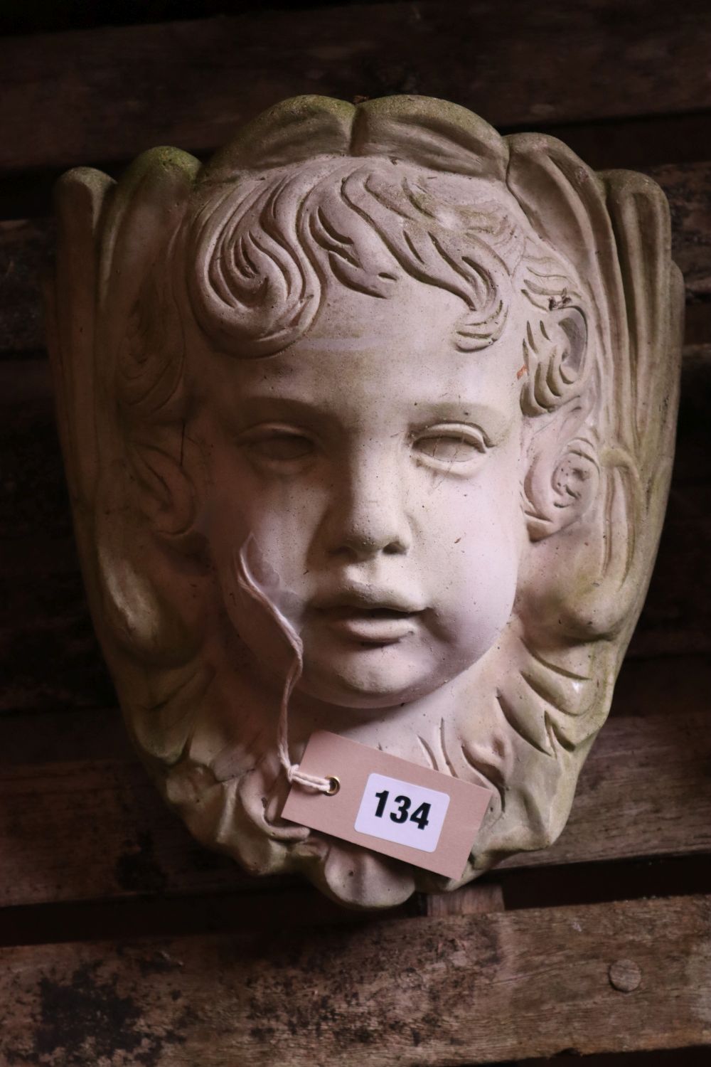 Three reconstituted stone cherub garden wall appliques, tallest 32cm
